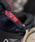 Applying Blue 243 Oil-Resistant Threadlocker to metal fastener for automotive use, demonstrating medium-strength adhesion and oil resistance.