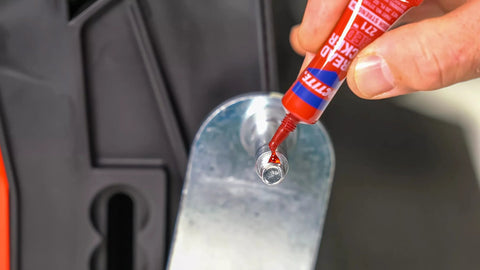 Applying Permanent Thread Lock And Seal For Nuts Bolts And Fasteners High Strength Red 271 to a bolt on metal machinery part