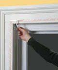 Applying Indoor Shrink Window Kit For Large Windows And Patio Doors 84 Inch By 110 Inch Clear Film to window frame