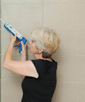 Woman applying Waterproof 100 Percent Silicone Caulk And Sealant For Bathrooms And Kitchens, 10 Oz Cartridge