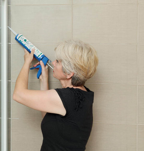 Woman applying Waterproof 100 Percent Silicone Caulk And Sealant For Bathrooms And Kitchens, 10 Oz Cartridge