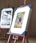 Framed artworks on easels with decorative images in a gallery setting
