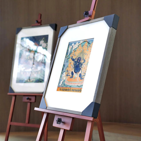 Framed artworks on easels with decorative images in a gallery setting