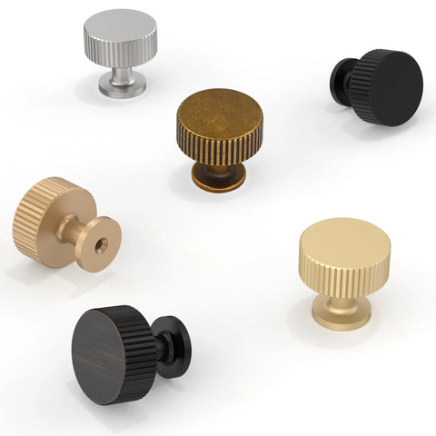 Assorted cabinet knobs in various finishes, including antique brass, displayed on white background for kitchen and furniture use.