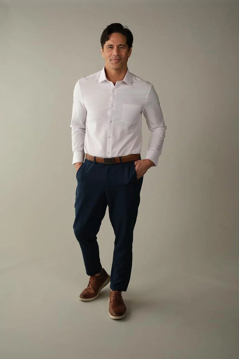 Man wearing Athletic Fit White Dress Shirt For Men With 4 Way Stretch Performance, Wrinkle Free And Stain Resistant, standing confidently.