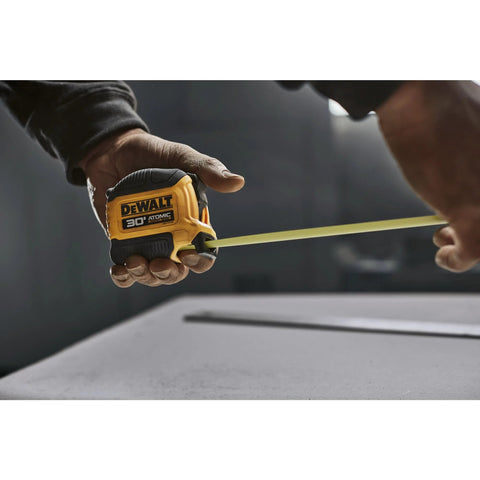 Person using Atomic Compact 30 Ft Tape Measure With Finger Brake for Precision and One Hand Quick Measurement on a job site