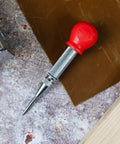 5-Inch Automatic Center Punch For Metal And Other Materials, Spring Loaded Center Punch Tool with red cap on a workbench