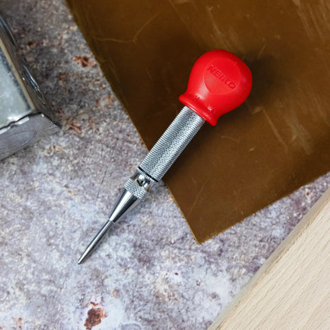 5-Inch Automatic Center Punch For Metal And Other Materials, Spring Loaded Center Punch Tool with red cap on a workbench