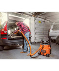 Person using 7 piece auto detailing hose kit with 1 1/4 inch hoses for cleaning car trunk in garage