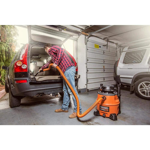 Person using 7 piece auto detailing hose kit with 1 1/4 inch hoses for cleaning car trunk in garage