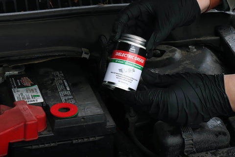 AGS Automotive Solutions Brush Top Can Dielectric Silicone Grease Compound for All Electrical Components and Connectors, 4oz, in use next to car battery
