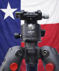 Front view of Ball Head Mount Adapter For BOG DeathGrip Tripod With Arca Swiss Plate and hardware against a Texas flag backdrop.