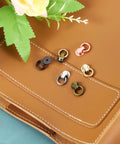 Ball Stud Rivet Set For Purses And Leather Crafting, Four Pieces With D Ring Connector, on leather background, multiple colors