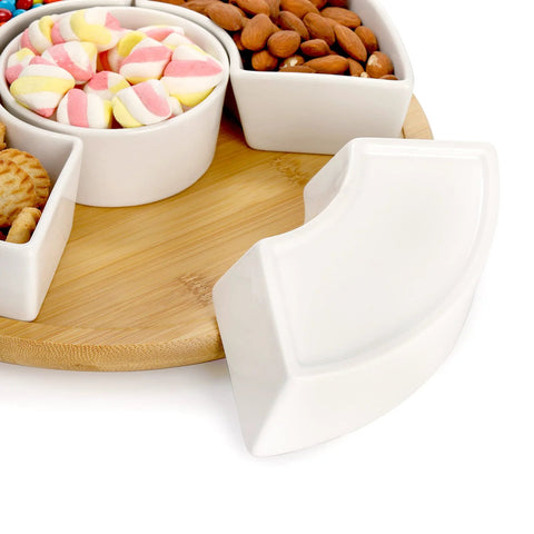 Divided Serving Dish Lazy Susan With 360 Degree Rotating Porcelain Tray on bamboo base, showing compartments with snacks and candy.