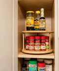 Eco Friendly Bamboo Wood Two Tier Turntable Ten Inch Diameter Kitchen Lazy Susan storing spices and condiments in a cabinet.