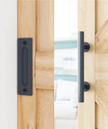 8.2 FT Heavy Duty Sturdy Sliding Barn Door Hardware Kit, Black, showing pull handle installed on wooden door panel