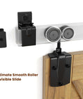 Close-up of the mounting bracket and rollers from the 7 Foot Box Rail Barn Door Hardware Kit For Exterior And Interior Doors Sliding Heavy Duty Wall Mount Kit Easy To Install Fits Doors Up To 42 Inch Wide Includes 5 Track Brackets Zinc Plated Finish Has Corrosion Resistance And Supports Up To 450 Pounds fitted on a wooden door.