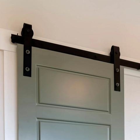 Barn Door Hardware Track Connector Splicing Plate Kit for Sliding Barn Doors installed on a grey door with black hardware