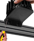 Installing Bass Shaker Mount For BST-1 Fits 100x100 Bass Vibrator on a metal rail with a screwdriver, highlighting reinforced design.