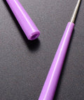 Close-up of pink Bead Hole Reamer Tool for Jewelry Making By EXCEART with an ergonomic handle on a dark surface.