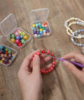 Person using 2 Piece Bead Reamer Tool Set With Diamond Tipped Reamers For Jewelry Making to enlarge bead holes on a bracelet.