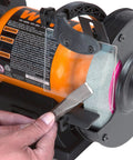 Using 2.1 Amp Bench Grinder with flexible work light for tool sharpening, visible are 6 inch by 3 quarter inch grinding wheels, black and orange.