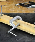 Bessey 4 Inch Drop Forged C Clamp with Swivel Pad clamping wood, showing galvanized finish and cold drawn steel spindle.