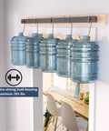 Hardware kit demonstrating load-bearing capacity with water jugs, showing durability of 52 Inch Bifold Barn Door Hardware Kit For Two Doors.