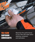 Mechanic applying Tri-Flow lubricant to a bicycle chain with a cloth