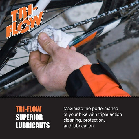 Mechanic applying Tri-Flow lubricant to a bicycle chain with a cloth
