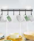 Adhesive Kitchen Hooks Utensil Hanger Holder Hanging Rack 2 Pack with mugs, wall mounted for cups, black metal rail with hooks.