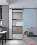 Black aluminum floor guide for sliding barn doors and bypass systems, anodized finish, installed on grey floor with 1/8 inch arm.