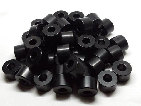 Pile of black anodized aluminum spacers with 3/4 inch outer diameter and 3/8 inch bore, unthreaded for precise mounting.