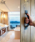 9 Inch Sliding Barn Door Handle Set In Black For Interior And Exterior Doors, Heavy Duty Pull Handle For Sliding Barn Doors, Easy To Install, Rust Resistant Carbon Steel With Frosted Black Finish being held by a hand on a wooden door in a luxurious bathroom background.