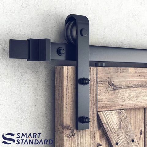 Close-up of 10FT Sliding Barn Door Hardware Kit, black J shape hanger on a wooden door panel, heavy duty track-mounted.