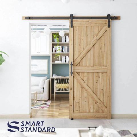 6.8 ft heavy duty sliding barn door hardware kit in black installed, showing wood door on aluminum alloy track in living room