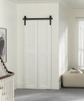 Installed 36" Bi-Folding Sliding Barn Door Hardware Track Kit, side mounted black roller, in a modern living room setting, door not included