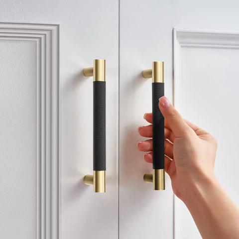 Hand touching Ten Pack Black Brass Kitchen Cabinet Handles And Drawer Pulls Brushed Gold Finish Modern Hardware on white cabinet