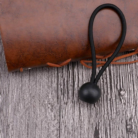 Single black bungee cord with rubber ball end on wooden surface, part of 30 Pack Heavy Duty Bungee Cords 4 Inch Black Rubber Core 4mm Thick