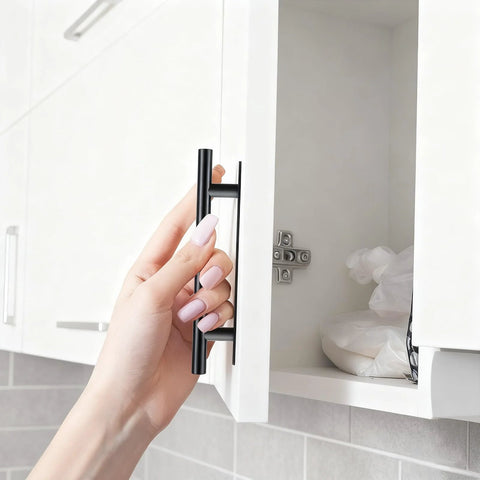 Hand installing black ABS plastic push-pull cabinet handle on a white door with no drill adhesive from 30 Pack Self Stick Push Pull Cabinet Handles.