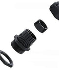 Exploded view of a black plastic cable gland with four separate components including nut, washer, body, and gland seal