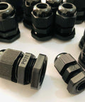 Assorted black cable glands labeled PG11 for secure wire connections on machinery or appliances