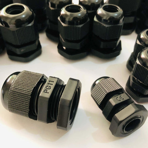 Assorted black cable glands labeled PG11 for secure wire connections on machinery or appliances