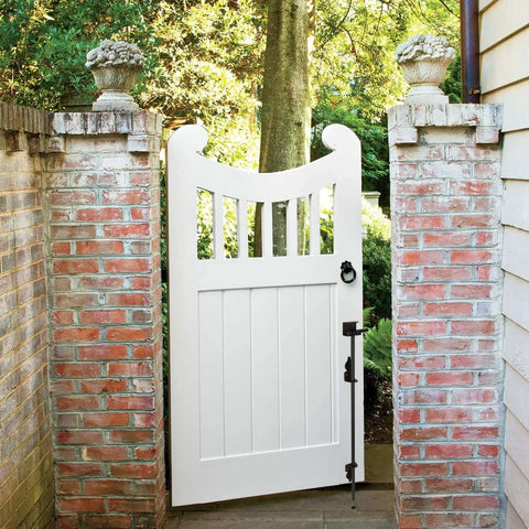 White wooden gate with installed 18 Inch Heavy Duty Cane Bolt Drop Rod For Gates And Fences Ground Latch For Wooden And Metal Gates.