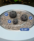 Hollow Ceramic Balls set of 12 round fire stones for 19 inch outdoor fire pit, showing 3, 4, and 5 inch black balls on gravel
