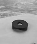 Close-up of a single black plastic curved washer from the 100 Pieces Black Plastic Curved Washers Set For Round Tubes M6 And M8 With PE Spacer Sleeves
