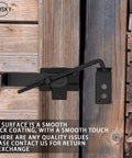 Sliding Door Latch With Hook Black Cam Latch for wooden doors, installed view on a rustic wood door in farm or garden setting.