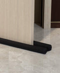 Door Noise Blocker 36 Inch Black Draft Stopper Silencer installed under a wooden door on marble floor