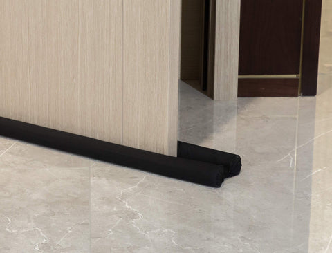 Door Noise Blocker 36 Inch Black Draft Stopper Silencer installed under a wooden door on marble floor