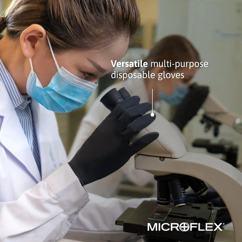 Person wearing Black Dragon 6mil Disposable Latex Gloves for Food Processing and Automotive using a microscope in a lab